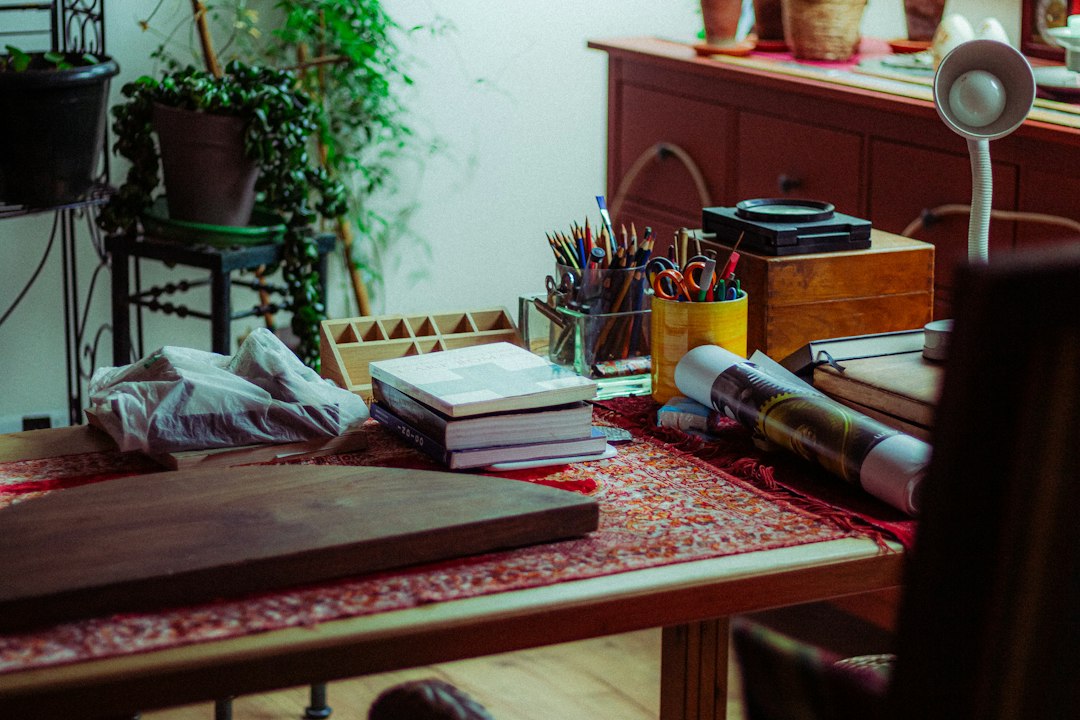 Warm cluttered desk with art supplies and plants