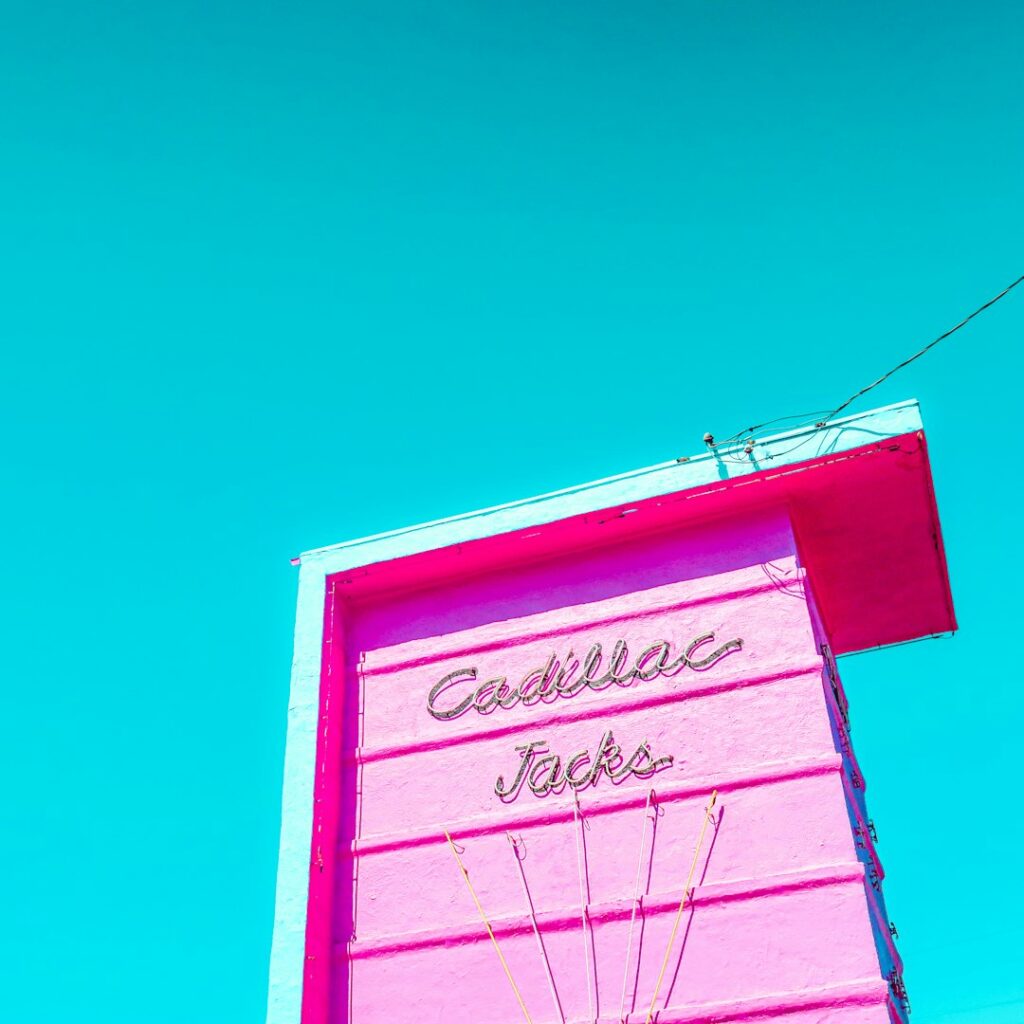 Pink roadside motel building and sign in warm light