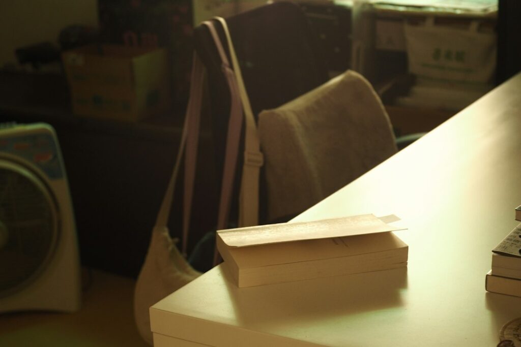 Stack of books on a publishing worktable, photographed by MChe Lee
