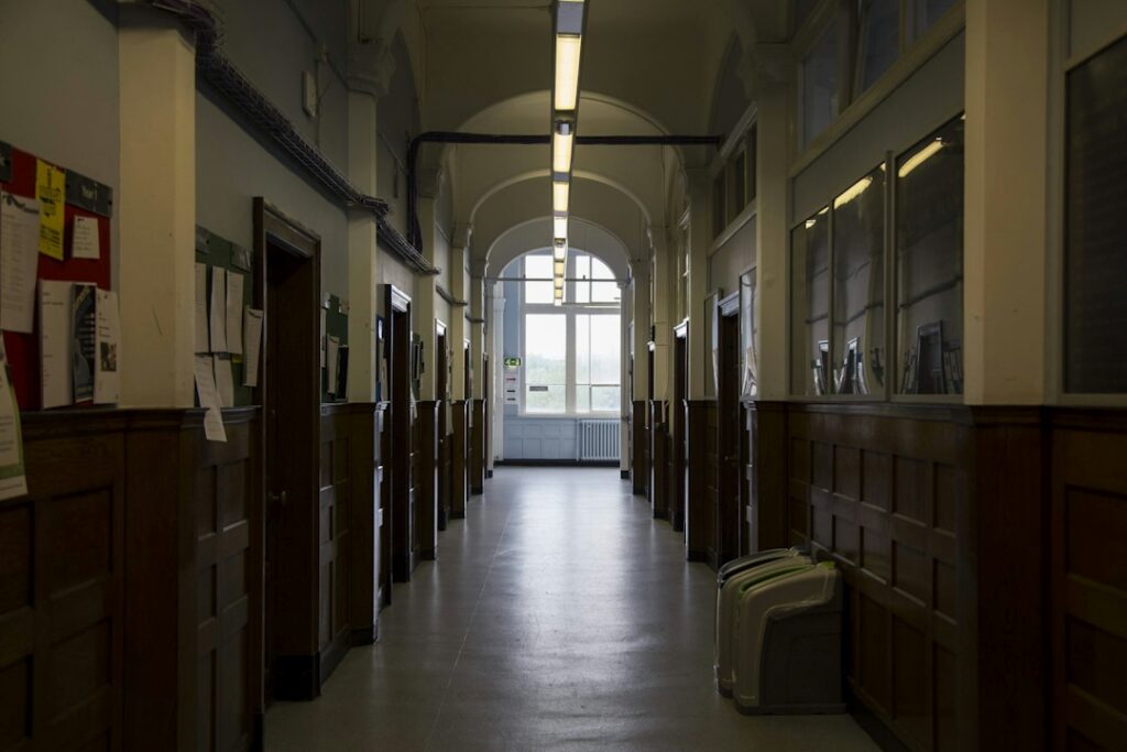 Empty university corridor, photograph by Rebecca Campbell, Unsplash
