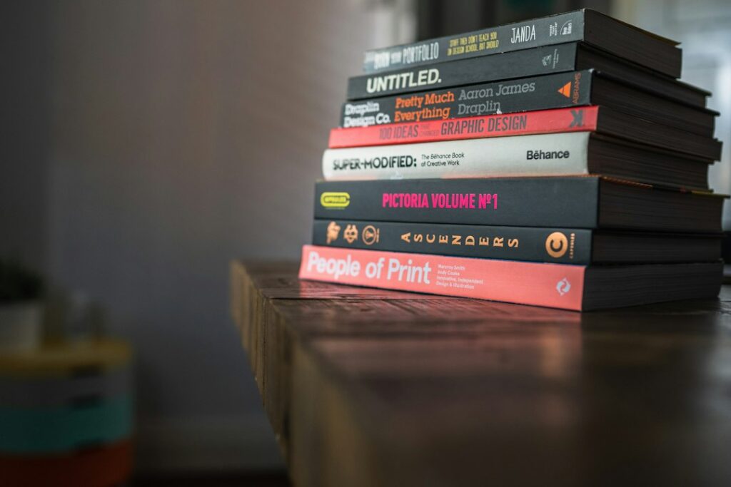 Stack of books on an old wooden table in low window light
